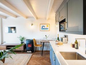 a kitchen with a sink and a table with a chair at The Cosy Cabin in Clapton in Gordano