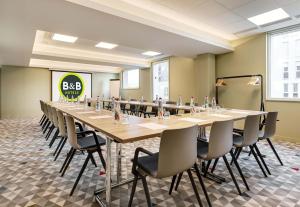 リールにあるB&B HOTEL Lille Lillenium Eurasantéの長いテーブルと椅子のある大きな会議室
