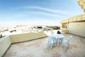 a balcony with a table and chairs and a view of the city at Hotel Julius in El Jem