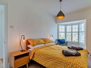 a bedroom with a bed and a blue chair at 3 Bed in Mundesley 75160 in Mundesley