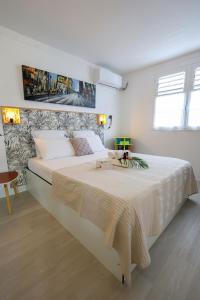 una camera bianca con un grande letto con una coperta di Cottage de la Plage - Le Gosier, proche plage, jacuzzi, location Prestige Caraïbes a Le Gosier Altre 51 foto