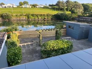 a garden with a pond and a wooden fence at West End Waterfront in Castletownbere
