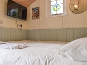 a white bed in a room with a window at Field View in St Austell