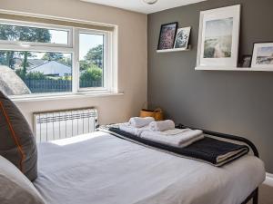 a bedroom with a bed with two towels on it at Seren Cottage By The Sea in Bodorgan