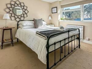 a bedroom with a large bed and a window at Seren Cottage By The Sea in Bodorgan
