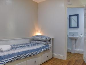 a small bedroom with a bed and a sink at Rascal's Rest in Whitby +8 photos