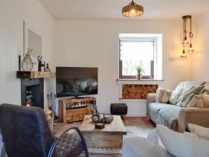 a living room with a couch and a fireplace at Black Spout Cottage in Moulin