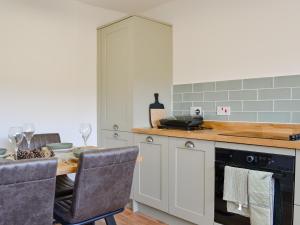 a kitchen with a table and a stove and a counter at Black Spout Cottage in Moulin +19 photos