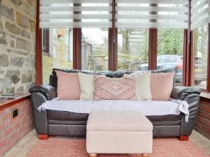 a leather couch sitting in front of a window at Black Spout Cottage in Moulin