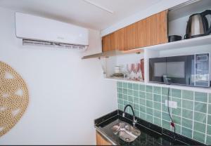 eine Küche mit grünen Fliesen und einer Spüle in der Unterkunft Flat Porto de Galinhas in Porto De Galinhas