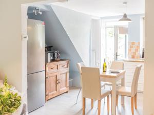 a kitchen with a table and a refrigerator at Beeswax Cottage in Dalton in Furness
