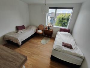 a small room with two beds and a window at Cozy villa apartment close to everything in Hørning