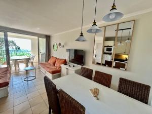 una cucina e un soggiorno con tavolo e sedie di Les Restanques vue mer Freesia a Grimaud