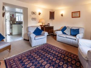 a living room with two chairs and a table at Colbridge Cottage in Docking