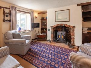 a living room with a couch and a fireplace at Colbridge Cottage in Docking
