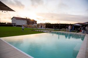 a swimming pool in a yard with people standing around it at MJ Guest House in Póvoa de Varzim