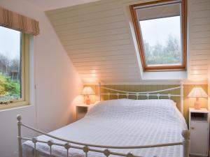 a bedroom with a bed and two windows at Bakers Retreat in Freshwater