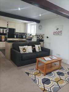 a living room with a couch and a coffee table at Olde Farm Holiday Cottages in Banham