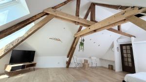 a room with wooden beams and a flat screen tv at La Champenoise in Troyes