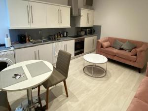 a kitchen and living room with a table and a couch at New York Apartment in Sheffield
