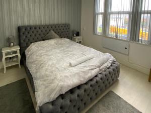 a bedroom with a large bed with a white comforter at New York Apartment in Sheffield
