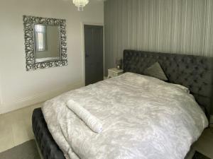 a bedroom with a large bed with a mirror on the wall at New York Apartment in Sheffield