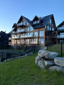 a large building on a hill with rocks in front of it at Stone Suite Zakopane in Zakopane