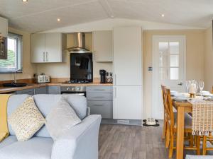 Una sala de estar y una cocina con un sofá y una mesa. en Sunshine Retreat, en Sewerby