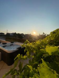 a hot tub in a garden with the sunset in the background at Villa Discover Evia - With Private Jacuzzi in Aliveri