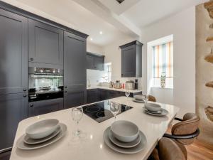 a kitchen with a table with plates and wine glasses at Sandy View - Uk43056 in Saundersfoot