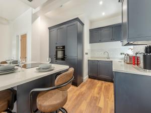 a kitchen with black cabinets and a counter top at Sandy View - Uk43056 in Saundersfoot +17 photos