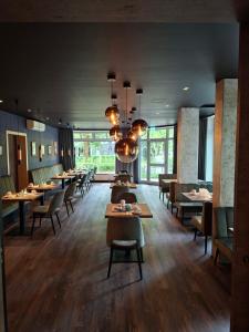 a dining room with tables and chairs and a chandelier at Kurpension Freudenstein in Bad Füssing