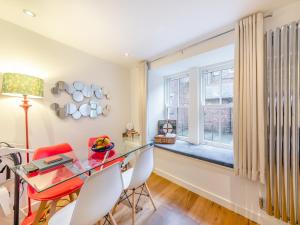 a dining room with a glass table and chairs and a window at Town Square Apartment - Uk45611 in Alnwick