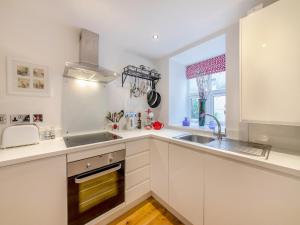 a kitchen with white cabinets and a sink and a window at Town Square Apartment - Uk45611 in Alnwick +7 photos
