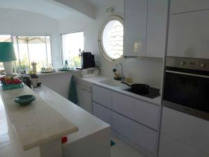 a kitchen with white cabinets and a sink and a window at Sur la plage in Lumio