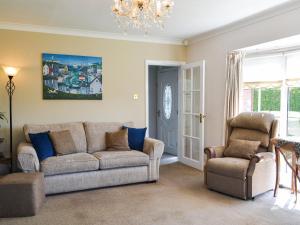 a living room with a couch and two chairs at Corner Cottage in Sewerby