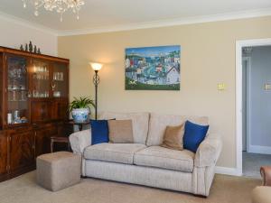a living room with a couch and blue pillows at Corner Cottage in Sewerby