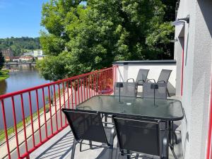 Železný BrodRiverside Luxury Apartments & Café - Exclusive holiday house with river view的河畔阳台的桌椅