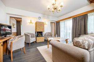 a living room with a bed and a tv and a couch at Hotel Edenlehen in Mayrhofen