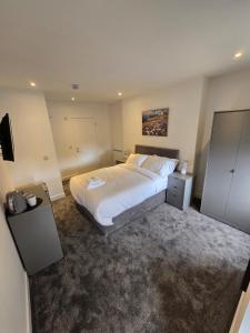 a bedroom with a large white bed and a television at Taigh Mor in Elgin