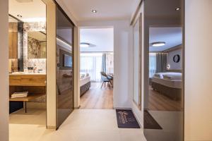 una camera da letto con un letto e un bagno con uno specchio di Hotel Edenlehen a Mayrhofen