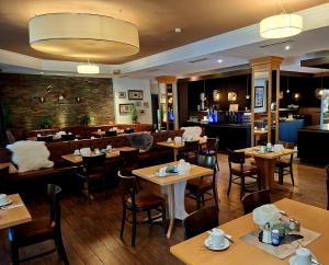 a restaurant with tables and chairs and a bar at Kurpension Freudenstein in Bad Füssing