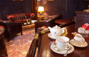 a room with a table with tea cups and chairs at Metropol Hotel in Calais