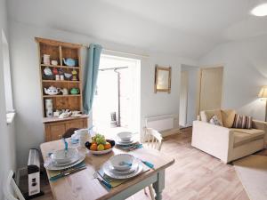 a living room with a table and a couch at Shrimp Cottage - E5415 in Kessingland
