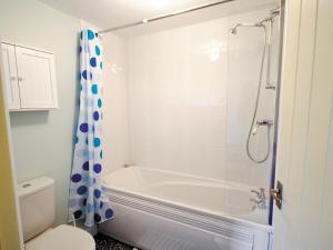 a bathroom with a tub and a toilet and a shower at Shrimp Cottage - E5415 in Kessingland +2 photos