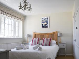 ein Schlafzimmer mit zwei Betten mit weißen Laken und einem Kronleuchter in der Unterkunft Kings Cottages 9 in Salcombe