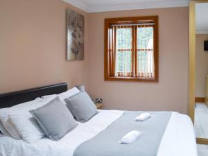 a bedroom with a large white bed with a window at George's Gaff - E4432 in Ingoldmells