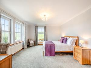 a bedroom with a bed and two windows at Kerrytonlia Cottage in Mountstuart +27 photos