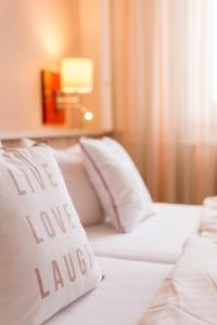
a white bed with pillows and pillows on top of it at Hotel Leander in Bitburg
