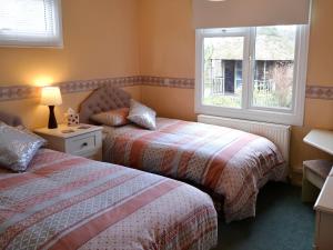 ein Schlafzimmer mit zwei Betten und einem Fenster in der Unterkunft The Wherry in Wroxham + 4 Fotos